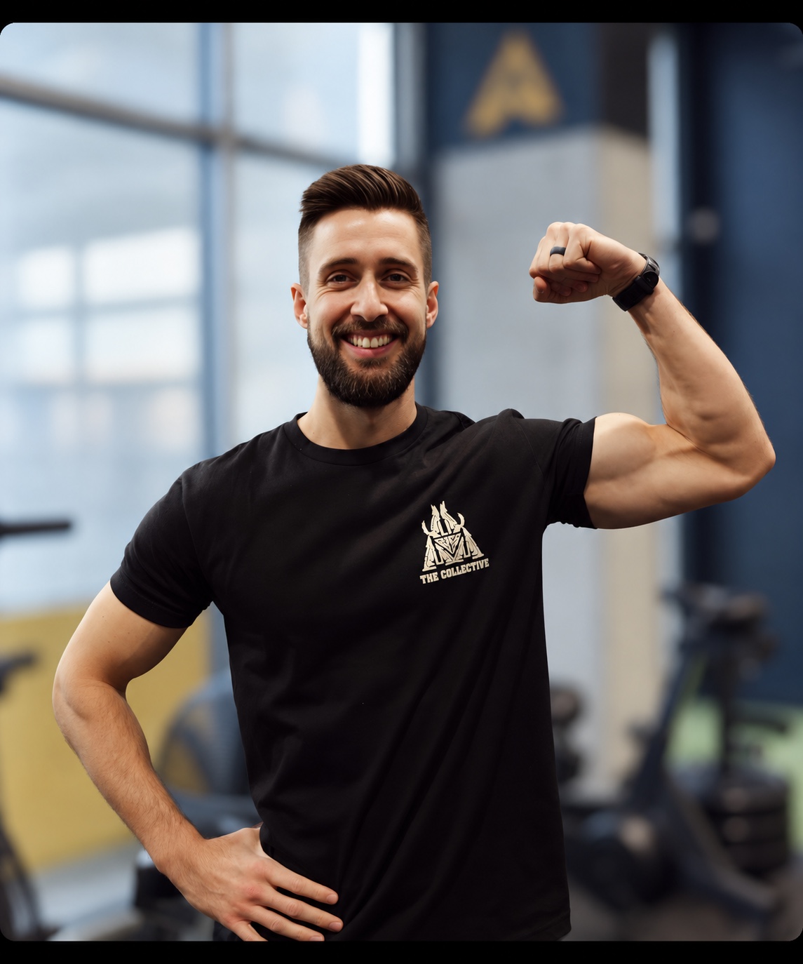 Caleb Greig smiling and flexing one arm in a black shirt