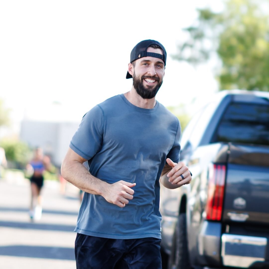 Caleb Greig smiling outdoors in a blue shirt and cap